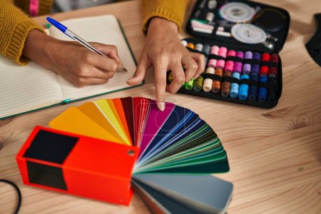Téléchargez les photos : Young blonde woman dressmaker choosing cloth color at designer studio - en image libre de droit