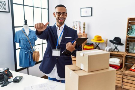 Photo for African american man working as manager at retail boutique approving doing positive gesture with hand, thumbs up smiling and happy for success. winner gesture. - Royalty Free Image