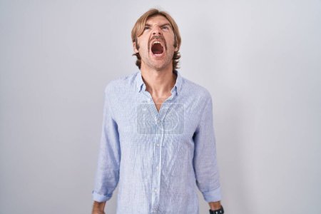 Photo for Caucasian man with mustache standing over white background angry and mad screaming frustrated and furious, shouting with anger. rage and aggressive concept. - Royalty Free Image