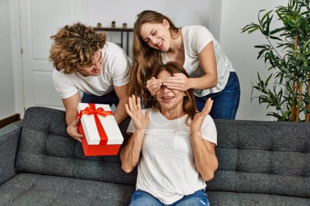 Téléchargez les photos : Mère et couple surprise avec cadeau d'anniversaire à la maison - en image libre de droit