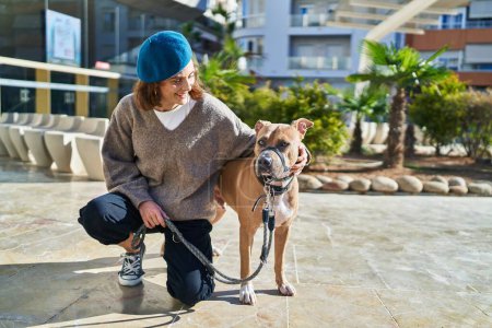 Photo for Young caucasian woman smiling confident hugging dog at park - Royalty Free Image