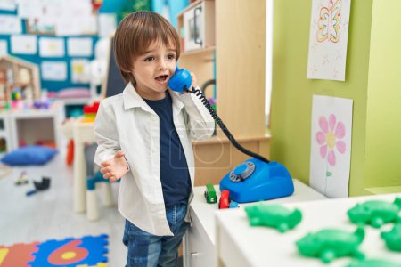 Téléchargez les photos : Adorable toddler playing telephone toy standing at kindergarten - en image libre de droit