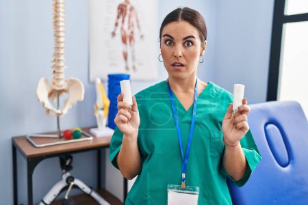 Photo for Young hispanic woman holding strip band for sprains in shock face, looking skeptical and sarcastic, surprised with open mouth - Royalty Free Image