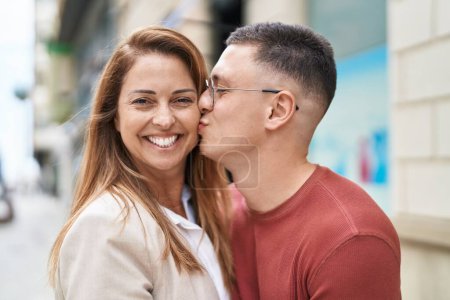 Téléchargez les photos : Homme et femme mère et fils se câlinent et s'embrassent dans la rue - en image libre de droit