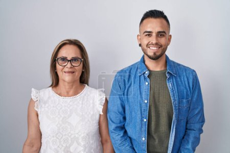 Téléchargez les photos : Mère hispanique et son fils debout avec un sourire heureux et cool sur le visage. chanceux. - en image libre de droit