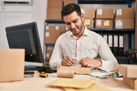 Photo for Young hispanic man e-commerce business worker prepare package at office - Royalty Free Image