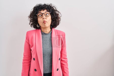 Photo for Hispanic woman with curly hair standing over isolated background making fish face with lips, crazy and comical gesture. funny expression. - Royalty Free Image