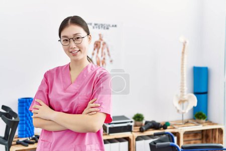 Photo for Young asian woman smiling working at physiotherapy clinic - Royalty Free Image