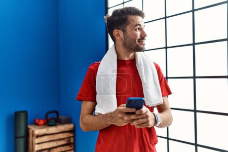 Téléchargez les photos : Young hispanic man wearing sportswear using smartphone at sport center - en image libre de droit
