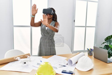 Photo for Young african american woman architect using virtual reality glasses at architecture studio - Royalty Free Image