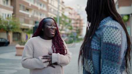 Téléchargez les photos : Deux amis afro-américains souriant confiants debout ensemble dans la rue - en image libre de droit