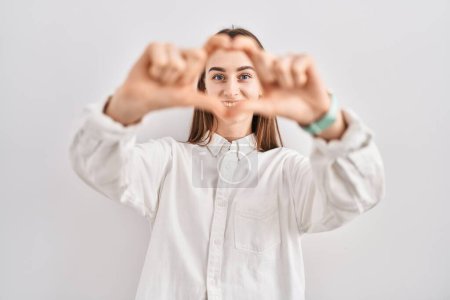 Photo for Young caucasian woman standing over isolated background smiling in love doing heart symbol shape with hands. romantic concept. - Royalty Free Image