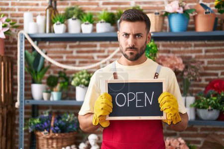 Photo for Handsome hispanic man working at florist holding open sign skeptic and nervous, frowning upset because of problem. negative person. - Royalty Free Image