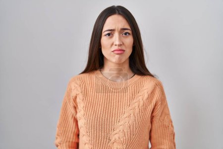 Photo for Young brunette woman standing over white background depressed and worry for distress, crying angry and afraid. sad expression. - Royalty Free Image