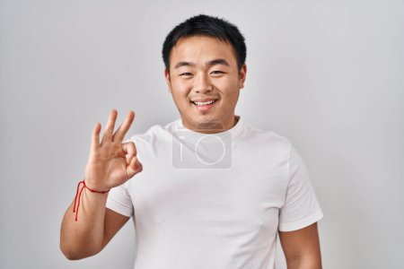 Photo for Young chinese man standing over white background showing and pointing up with fingers number three while smiling confident and happy. - Royalty Free Image