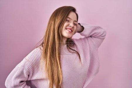 Photo for Young caucasian woman standing over pink background stretching back, tired and relaxed, sleepy and yawning for early morning - Royalty Free Image