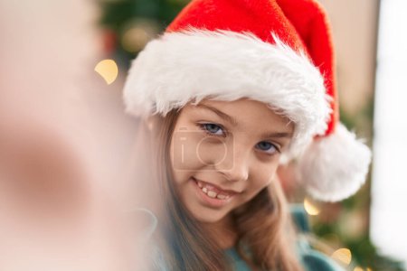 Photo for Adorable hispanic girl smiling confident make selfie standing by christmas tree at home - Royalty Free Image