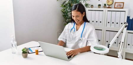 Photo for Young latin woman wearing doctor uniform working at clinic - Royalty Free Image