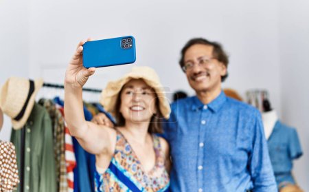 Photo for Middle age man and woman smiling confident make selfie by the smartphone at clothing store - Royalty Free Image