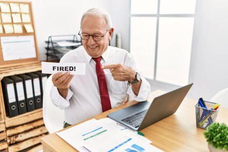 Photo for Senior business man holding fired banner at the office smiling happy pointing with hand and finger - Royalty Free Image