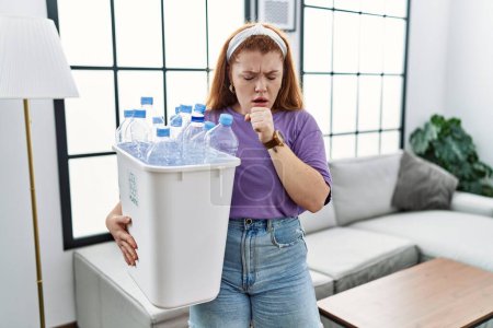 Téléchargez les photos : Young redhead woman holding recycling wastebasket with plastic bottles feeling unwell and coughing as symptom for cold or bronchitis. health care concept. - en image libre de droit