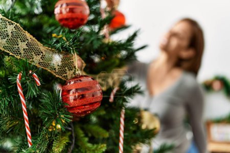 Téléchargez les photos : Jeune femme latine souriante décoration confiante arbre de Noël à la maison - en image libre de droit