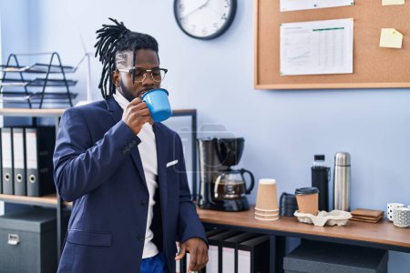 Foto de Trabajadora de negocios afroamericana bebiendo café en la oficina - Imagen libre de derechos
