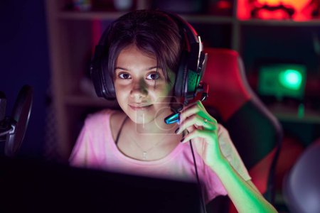 Photo for Adorable hispanic girl streamer playing video game using computer at gaming room - Royalty Free Image