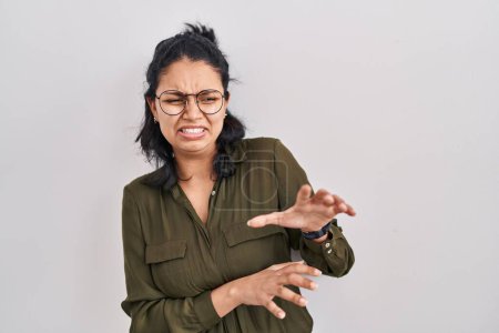 Téléchargez les photos : Hispanic woman with dark hair standing over isolated background disgusted expression, displeased and fearful doing disgust face because aversion reaction. with hands raised - en image libre de droit