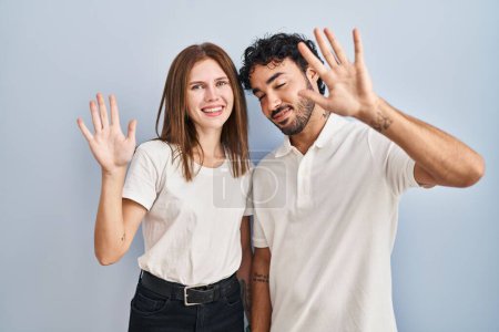 Téléchargez les photos : Jeune couple portant des vêtements décontractés debout ensemble montrant et pointant vers le haut avec les doigts numéro dix tout en souriant confiant et heureux. - en image libre de droit