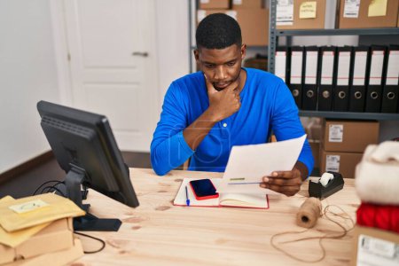 Téléchargez les photos : Young african american man ecommerce business worker worried reading document at office - en image libre de droit