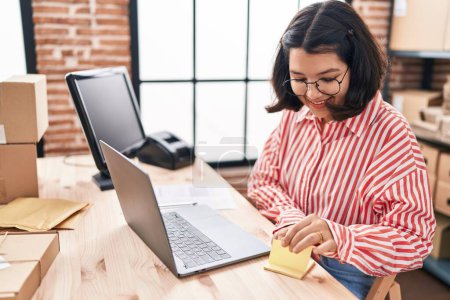 Téléchargez les photos : Jeune femme e-commerce travailleur d'entreprise tenant papier de rappel au bureau - en image libre de droit