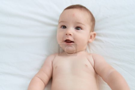 Photo for Adorable toddler smiling confident lying on bed at bedroom - Royalty Free Image