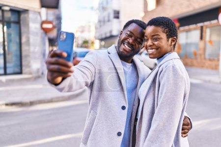 Photo for Man and woman couple standing together make selfie by the smartphone at street - Royalty Free Image