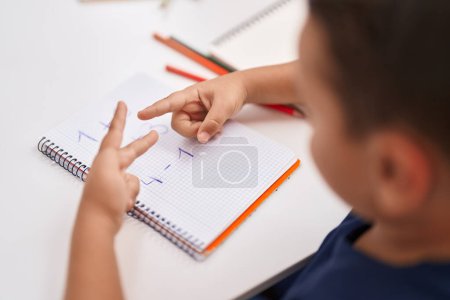 Téléchargez les photos : Adorable bambin hispanique faisant des exercices mathématiques compter avec les doigts en classe - en image libre de droit