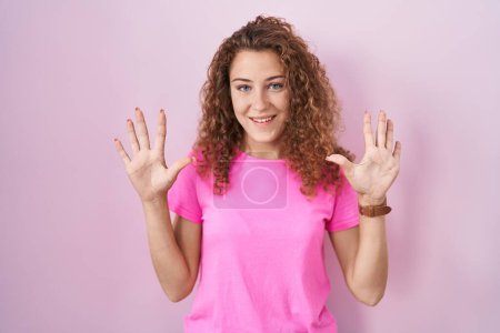 Téléchargez les photos : Young caucasian woman standing over pink background showing and pointing up with fingers number ten while smiling confident and happy. - en image libre de droit
