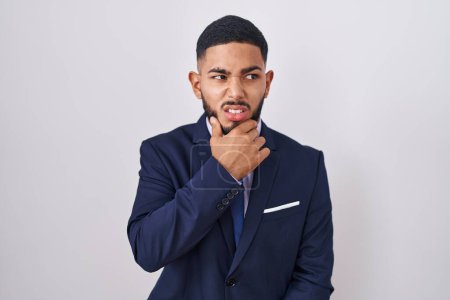 Photo for Young hispanic man wearing business suit and tie thinking worried about a question, concerned and nervous with hand on chin - Royalty Free Image