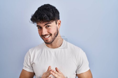 Téléchargez les photos : Homme hispanique avec la barbe debout sur fond blanc mains ensemble et les doigts croisés souriant détendu et joyeux. succès et optimisme - en image libre de droit