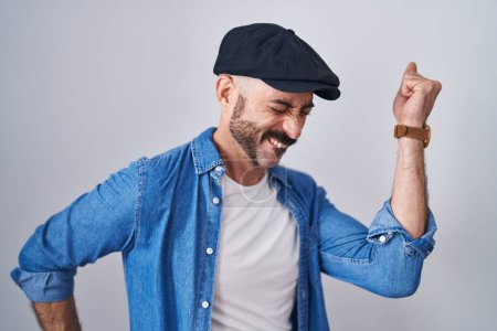 Foto de Hombre hispano con barba de pie sobre fondo aislado bailando feliz y alegre, sonriente moviéndose casual y confiado escuchando música - Imagen libre de derechos