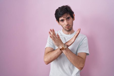 Téléchargez les photos : Jeune homme hispanique debout sur fond rose expression de rejet croisant les bras faisant signe négatif, visage en colère - en image libre de droit