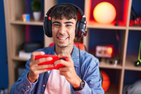 Photo for Young hispanic man streamer playing video game using smartphone at gaming room - Royalty Free Image