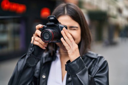 Photo for Young beautiful hispanic woman smiling confident using professional camera at street - Royalty Free Image