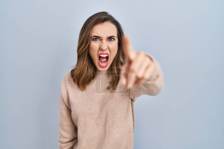 Photo for Young woman standing over isolated background pointing displeased and frustrated to the camera, angry and furious with you - Royalty Free Image