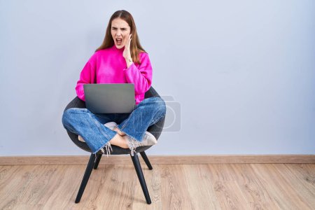 Photo for Young hispanic girl working using computer laptop shouting and screaming loud to side with hand on mouth. communication concept. - Royalty Free Image