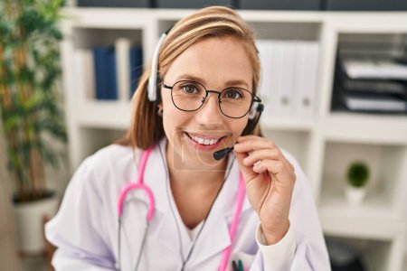 Photo for Young blonde woman doctor having telemedicine at clinic - Royalty Free Image