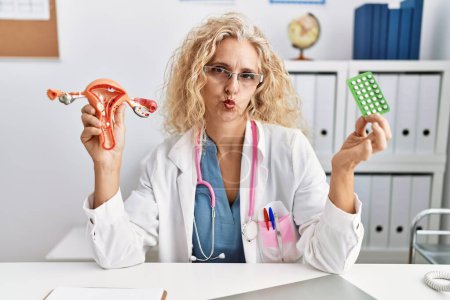 Photo for Middle age doctor woman holding birth control pills looking at the camera blowing a kiss being lovely and sexy. love expression. - Royalty Free Image