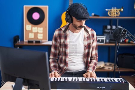 Téléchargez les photos : Jeune musicien hispanique jouant du clavier de piano au studio de musique - en image libre de droit