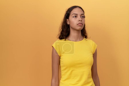 Téléchargez les photos : Young african american woman standing with serious expression over isolated yellow background - en image libre de droit