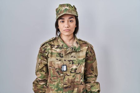 Photo for Young south asian woman wearing camouflage army uniform relaxed with serious expression on face. simple and natural looking at the camera. - Royalty Free Image