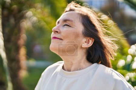 Téléchargez les photos : Middle age woman smiling confident breathing at park - en image libre de droit